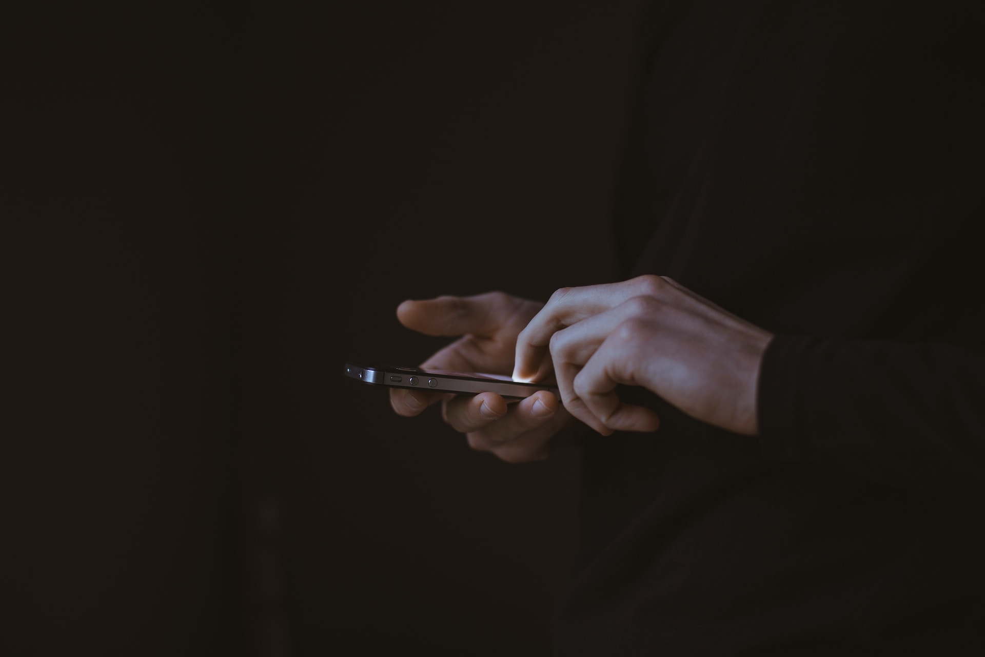 Grafika: telefon trzymany w dłoniach